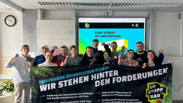 eine Gruppe an Jugendlichen hält ein Banner, auf dem die Forderungen für die Tarifrunde öffentlicher Dienst stehen.