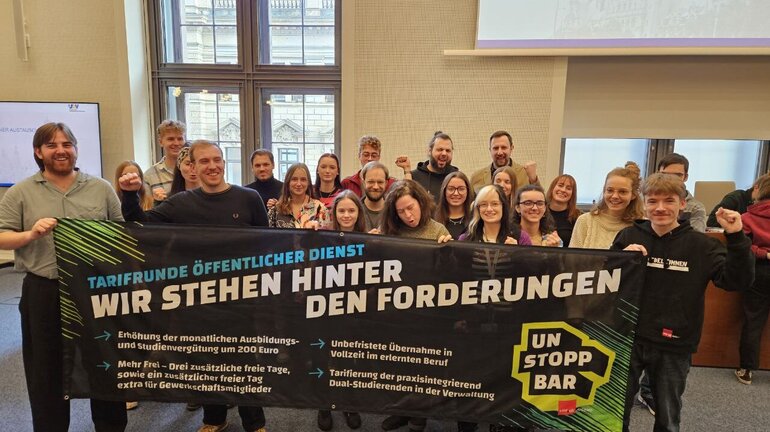 eine Gruppe an Jugendlichen hält ein Banner, auf dem die Forderungen für die Tarifrunde öffentlicher Dienst stehen.