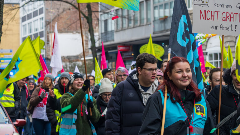 Eine große Gruppe Jugendlicher läuft streikend durch die Straßen und trägt dabei Fahnen, Banner und Schilder.