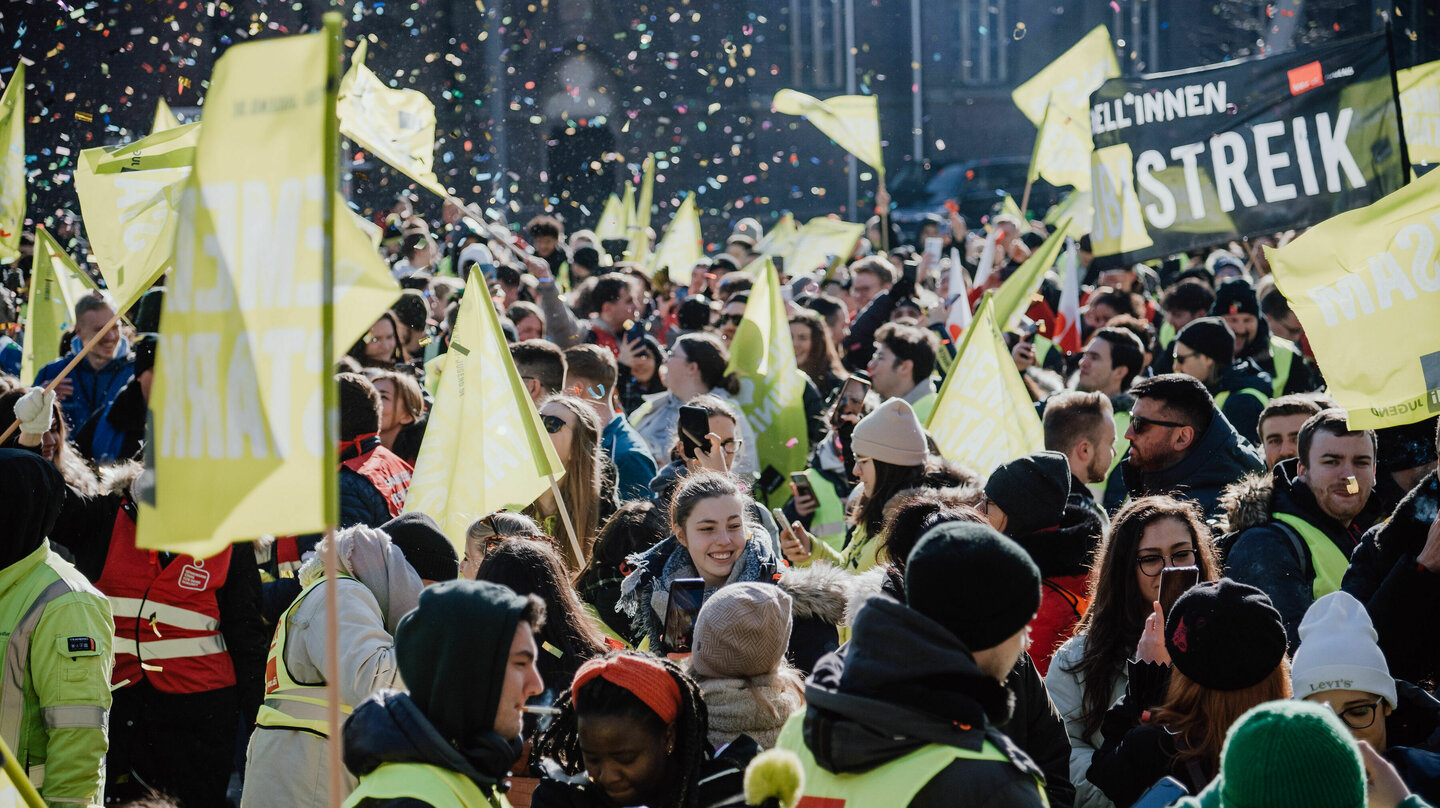 Demonstrierende Menschenmenge mit gelben verdi Westen und Fahnen stehen im Konfettiregen beim verdi Jugendstreiktag der Tarifrunde öffentlicher Dienst Bund und Kommunen in Gelsenkirchen 2023