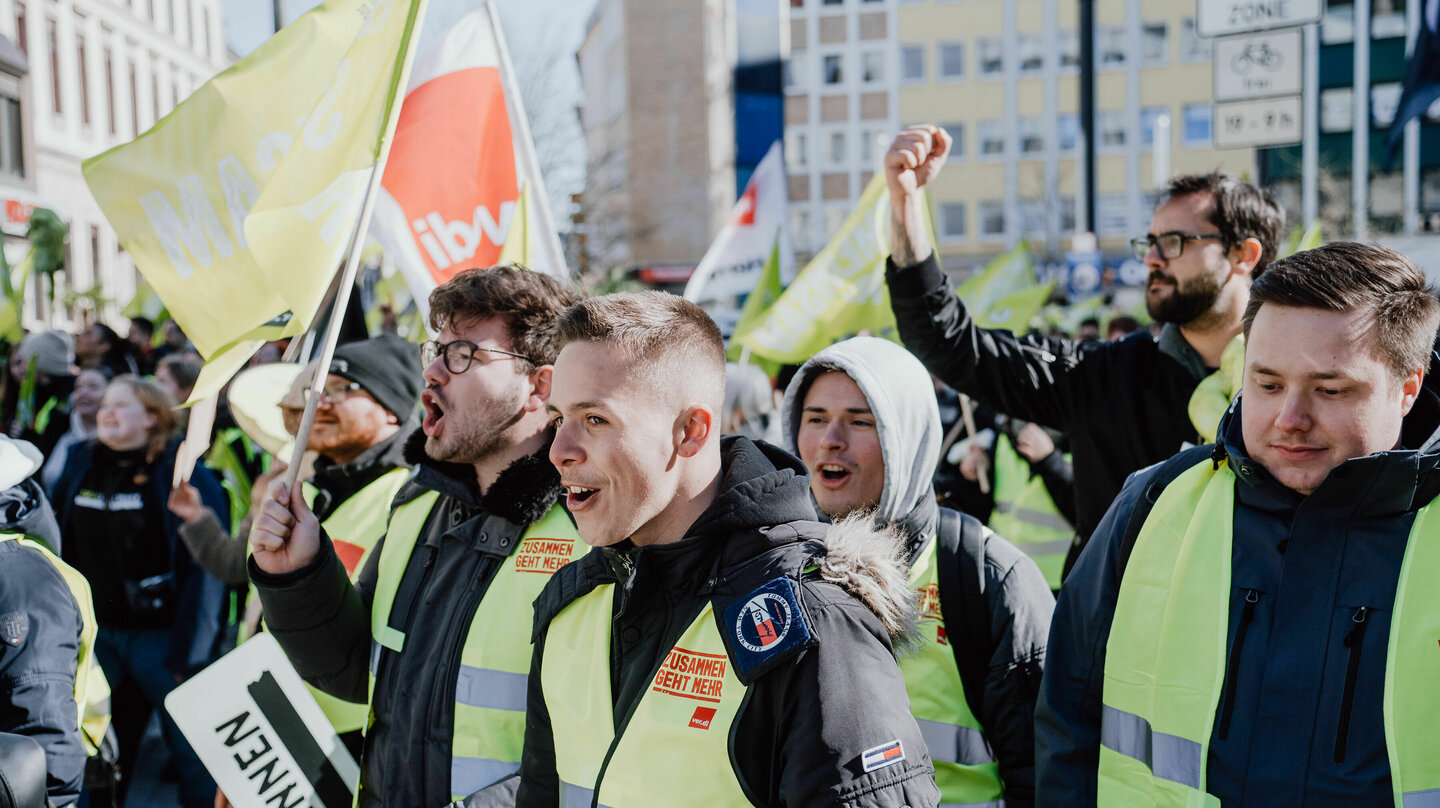 Drei Personen grölen mit verdi Westen auf denen zusammen geht mehr steht in der demonstrierenden Menschenmenge beim Jugendstreiktag der Tarifrunde öffentlicher Dienst Bund und Kommunen in Gelsenkirchen 2023